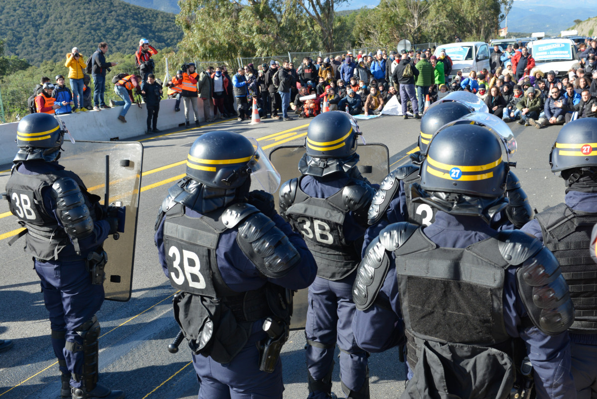 Agentes de policu00eda frente a la multitud que ha cortado la carretera de la AP 7 en La Jonquera (Girona)