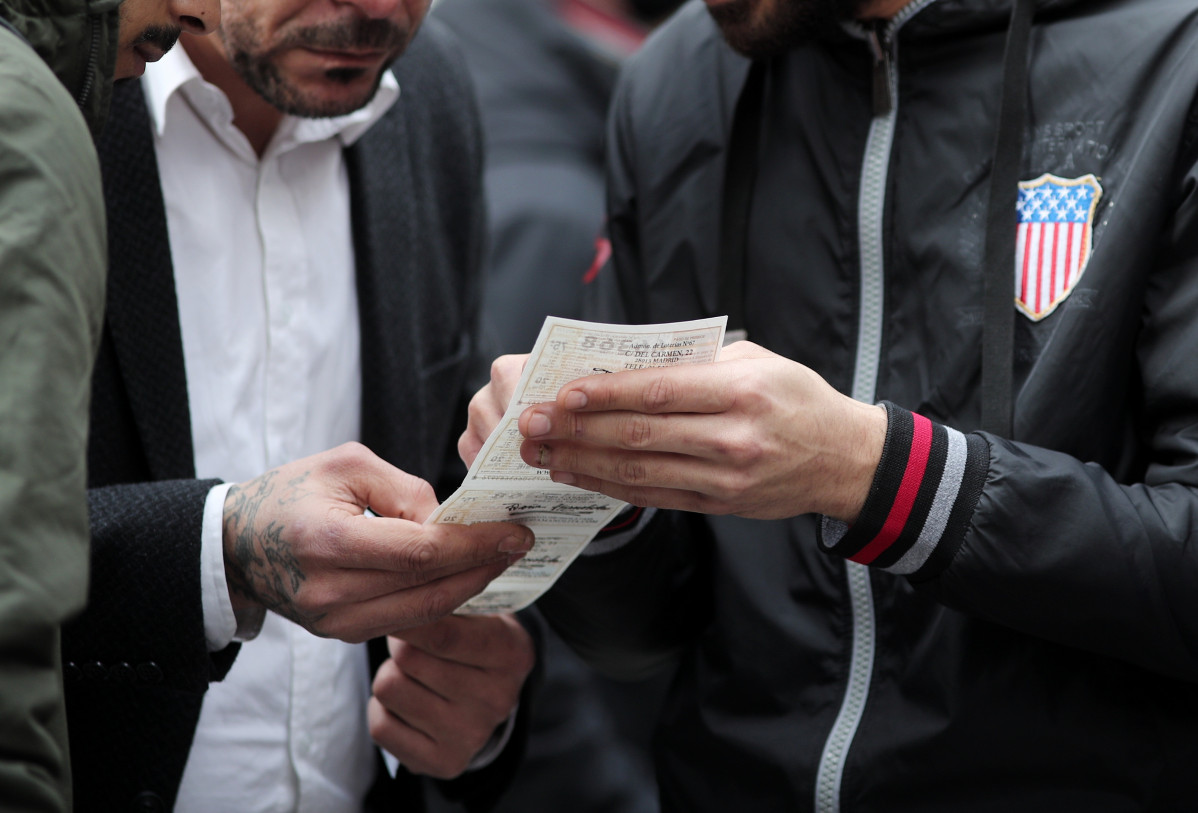 Un grupo de amigos mira el número del boleto de Lotería de Navidad que han comprado en la Plaza del Sol de Madrid (España), a 16 de diciembre de 2019 .