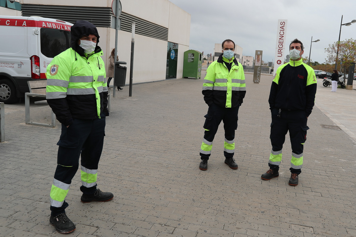Personal de ambulancias con mascarillas frente al Hospital Unviersitario La Fe de Valencia, uno de los centros públicos valencianos de referencia para el tratamiento de los pacientes afectados por co
