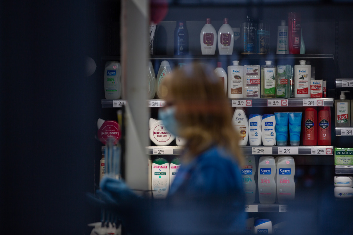 Una mujer protegida con mascarilla y guantes trabaja en una tienda durante el noveno día laborable desde que se decretó el estado de alarma en el país a consecuencia del coronavirus, en Barcelona/C