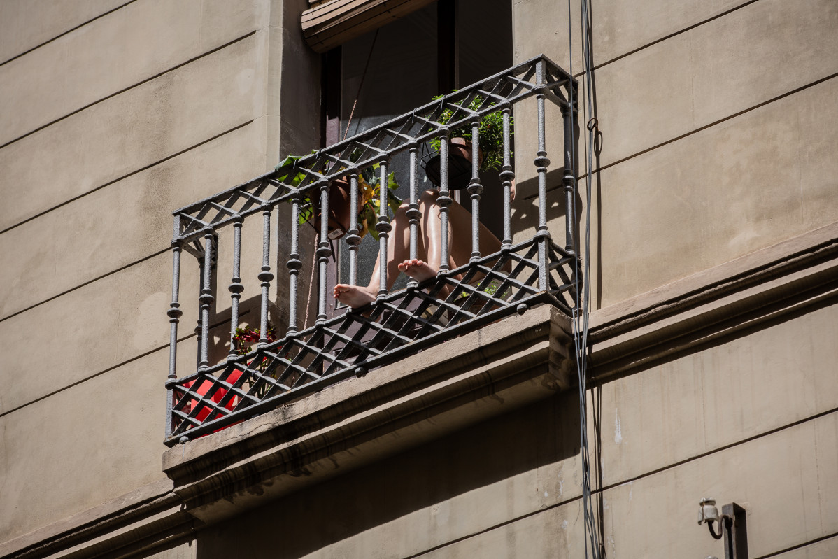 Una persona toma el sol en su balcón durante el tercer día de desconfinamiento de adultos y durante la fase 0 de la desescalada en la que se permite la apertura de ciertos establecimientos, en Barce