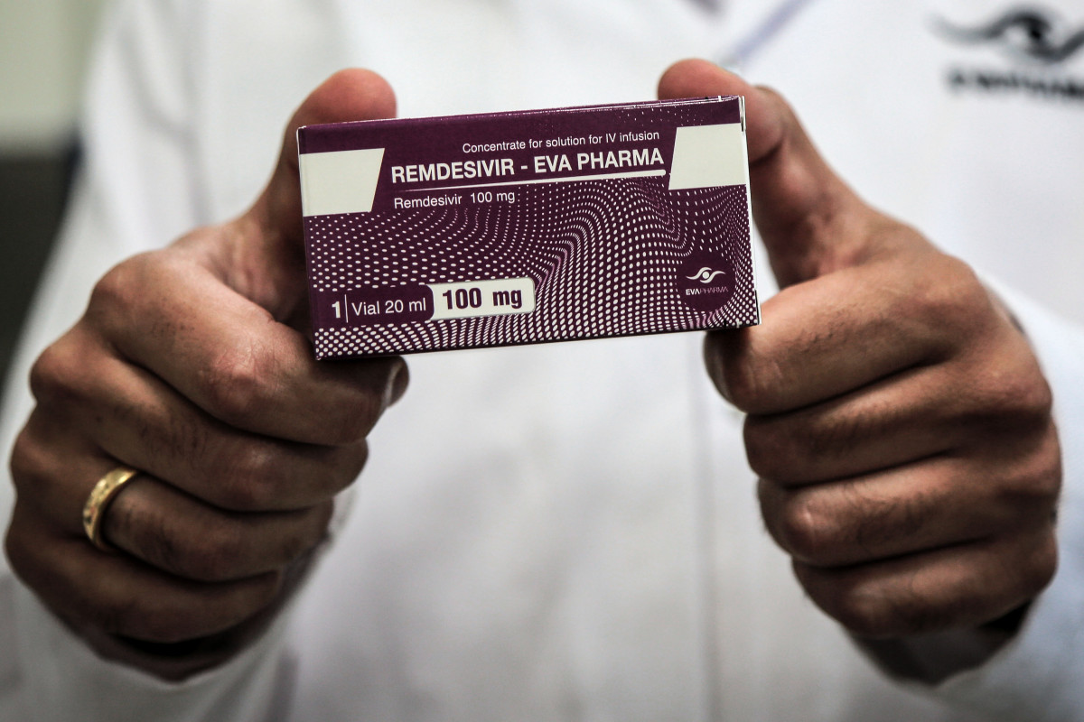 29 June 2020, Egypt, Giza: An employee of Egyptian pharmaceutical company Eva Pharma holds a pack containing vials of Remdesivir, a broad-spectrum antiviral medication approved as a specific treatment