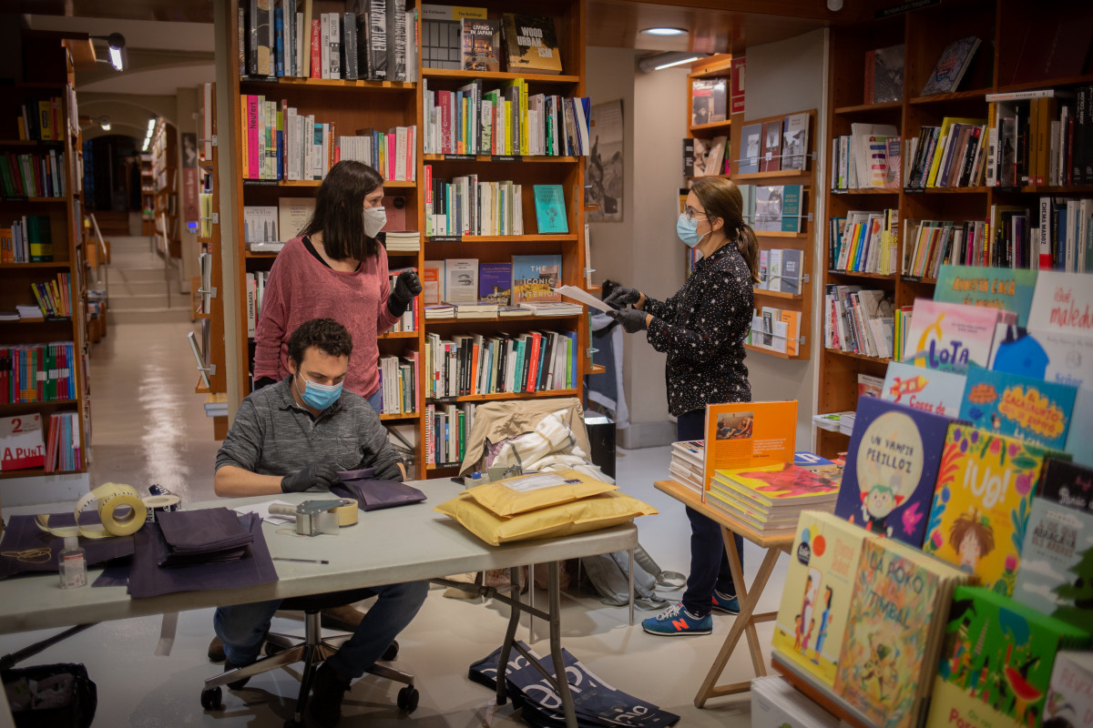 Trabajadores de la librería Laie Pau Claris librería-café ubicada en la calle catalana de Pau Claris, preparan libros y material antes de enviarlos. En Barcelona, Cataluña, (España), a 22 de abri