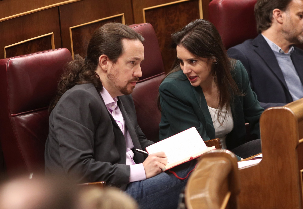 El secretario general de Podemos, Pablo Iglesias, y la portavoz parlamentaria de Unidas Podemos, Irene Montero, hablan en sus escaños en el Congreso de los Diputados durante la primera sesión del de