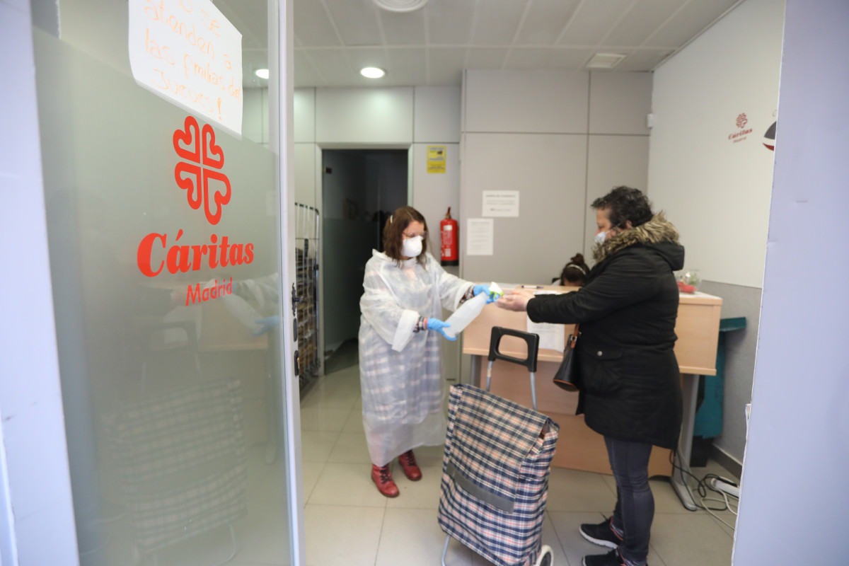 Una voluntaria de Cáritas y una usuaria en el local de la ONG situado en la calle Bravo Murillo de Madrid durante el inicio de la cuarta semana del estado de alarma decretado a consecuencia del coron