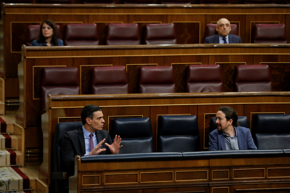 El presidente del Gobierno, Pedro Sánchez (i), conversa con el vicepresidente segundo, Pablo Iglesias, este miércoles, durante una sesión de control al Gobierno en el Congreso de los Diputados, en 