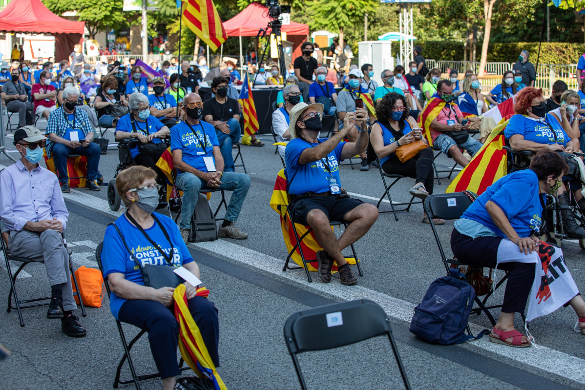 Participantes sentados en las sillas de separación en una concentración de la ANC, Òmnium y la AMI por la Diada, en la plaza Letamendi de Barcelona