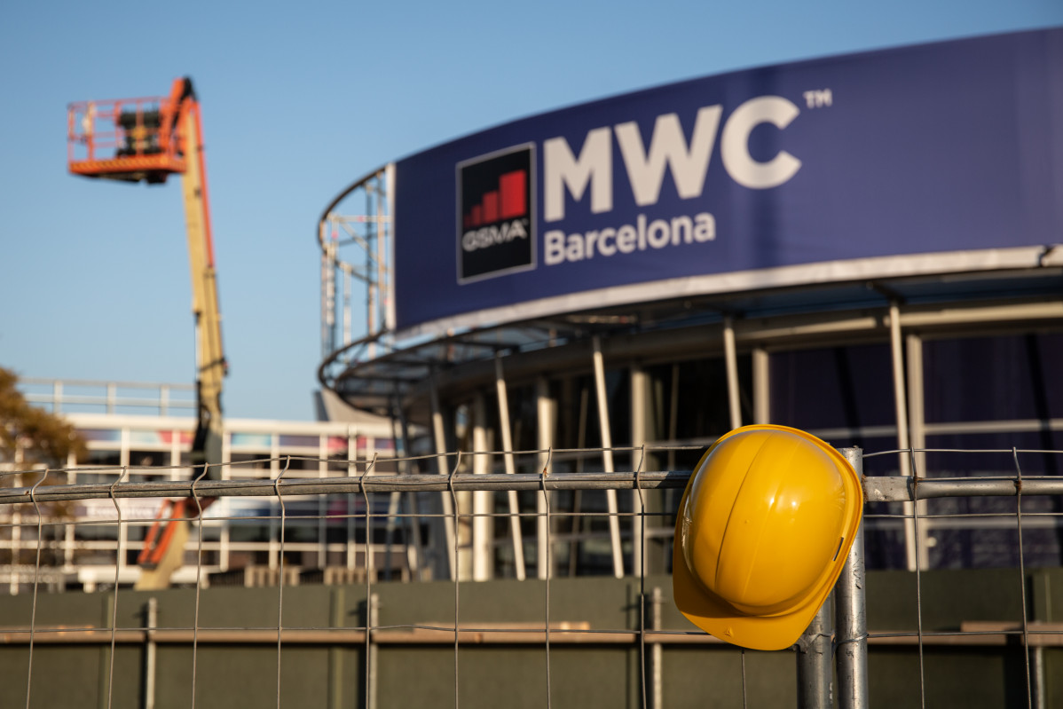 Un casco de obra colgado en una de las vallas que cierran el recinto del Mobile World Congress (MWC) de Barcelona durante el desmantelamiento de los stands tras la cancelación de la feria por la cris
