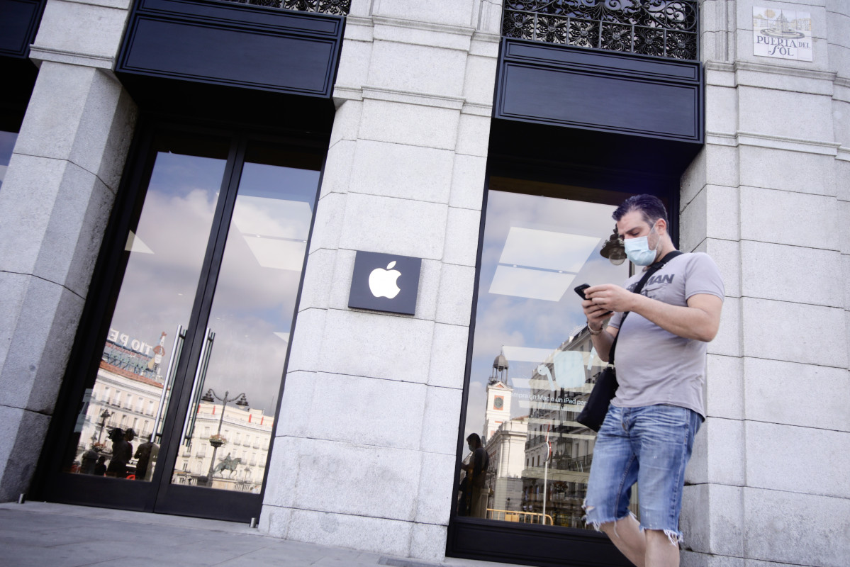 Una persona protegida con mascarilla pasa junto a la tienda Apple en la Puerta del Sol, en Madrid (España) a 24 de agosto de 2020.