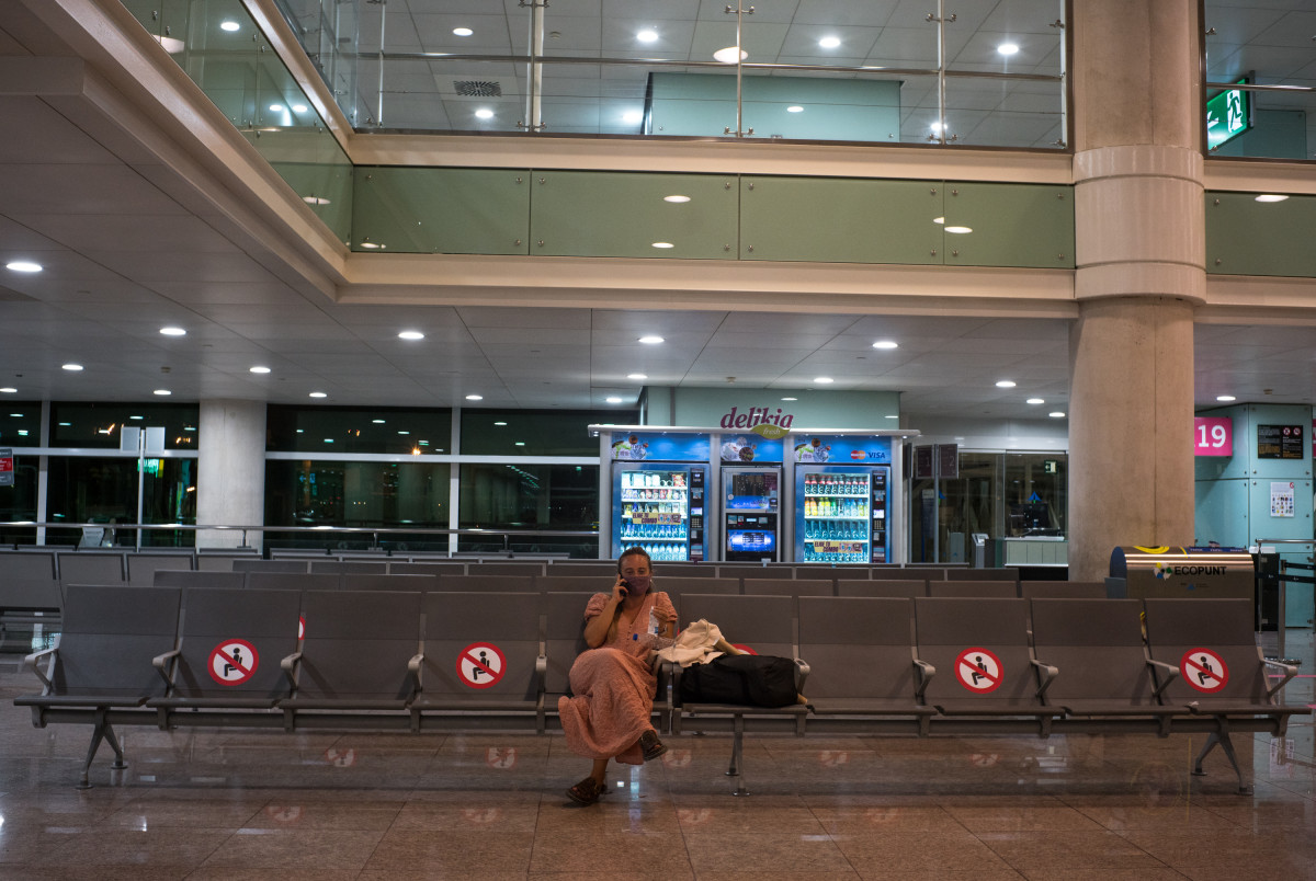 Una mujer espera sentada en unos asientos habilitados para preservar la distancia de seguridad en el Aeropuerto Josep Tarradellas Barcelona-El Prat, en Barcelona, Catalunya, (España), a 12 de septiembre de 2020.