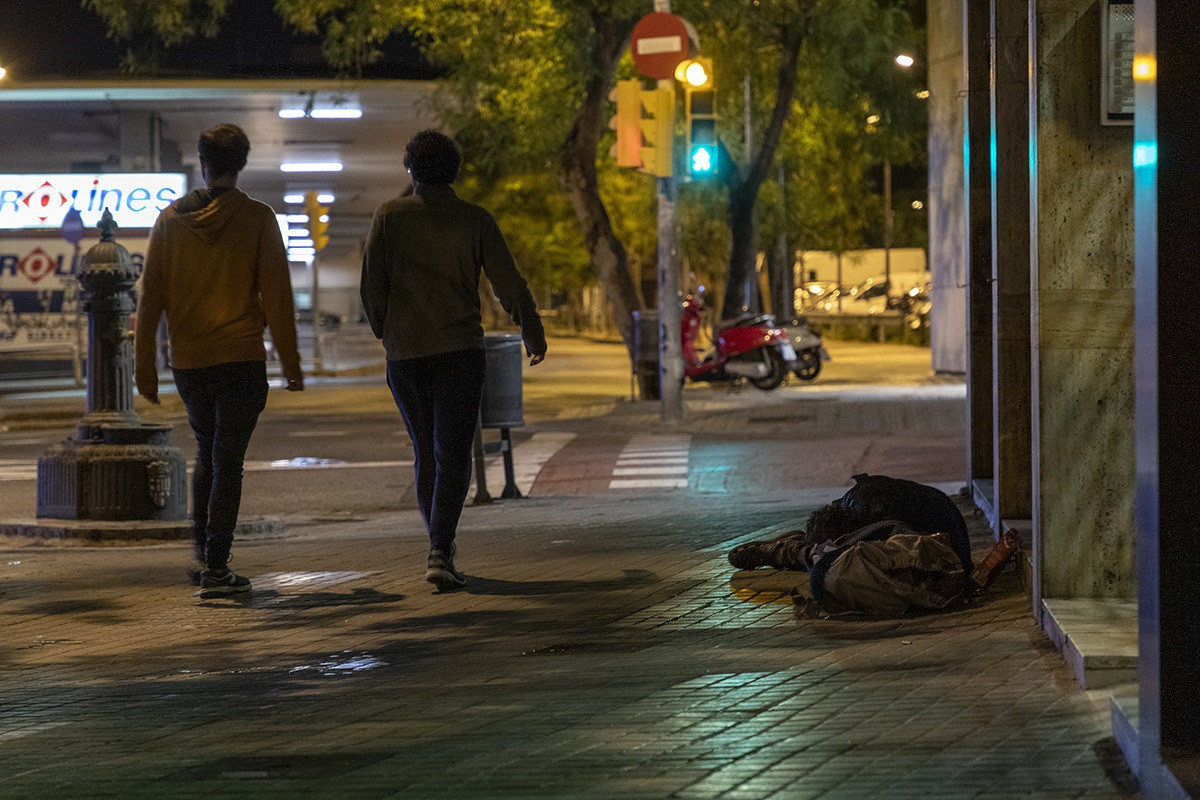 Una persona sin hogar durmiendo en la calle, cerca de la Estación de Sants de Barcelona, durante la noche del recuento de personas sin techo organizada por la Fundació Arrels el pasado 14 de mayo de