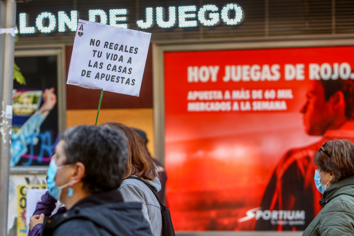 Una persona sostiene una pancarta donde se lee que 