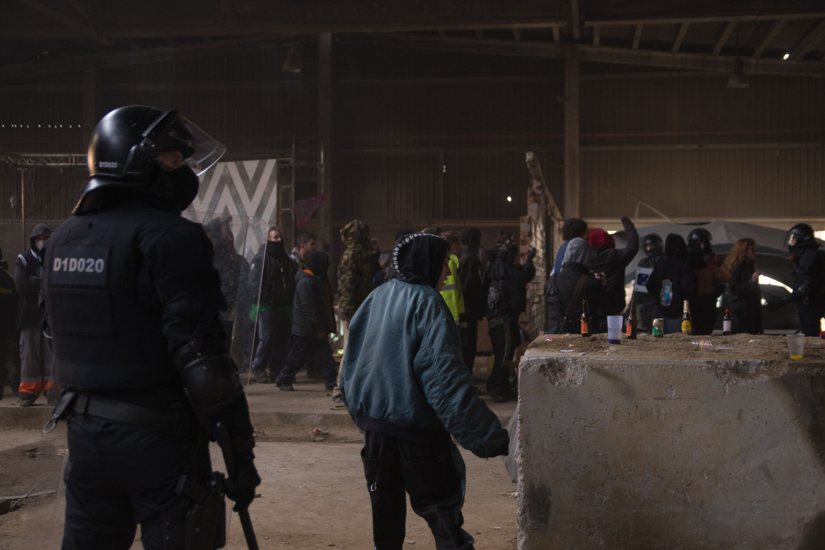 Un mosso d'esquadra frente a varios de los participantes en la ‘rave’ que se celebraba desde la noche de fin de año en Llinars del Vallès, Barcelona (España), a 2 de enero de 2021