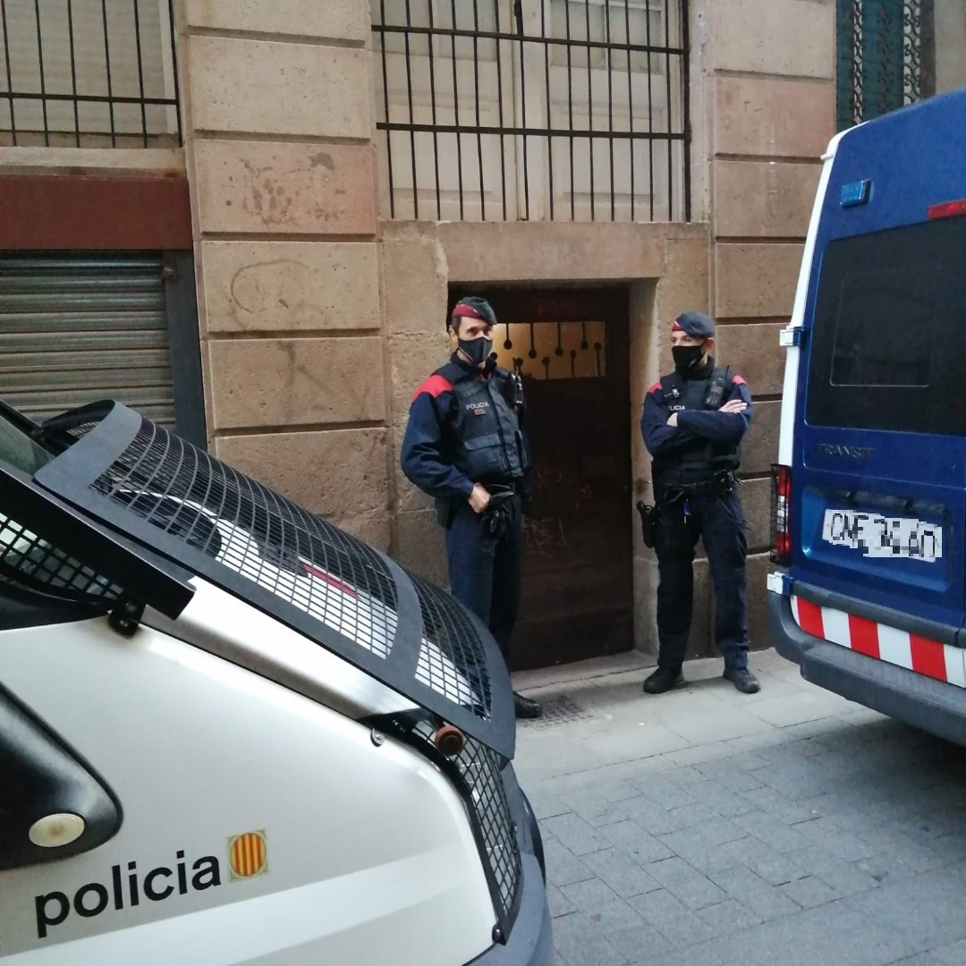 Dos agentes en la operación contra un piso en el Raval de Barcelona donde presuntamente se vendía droga.