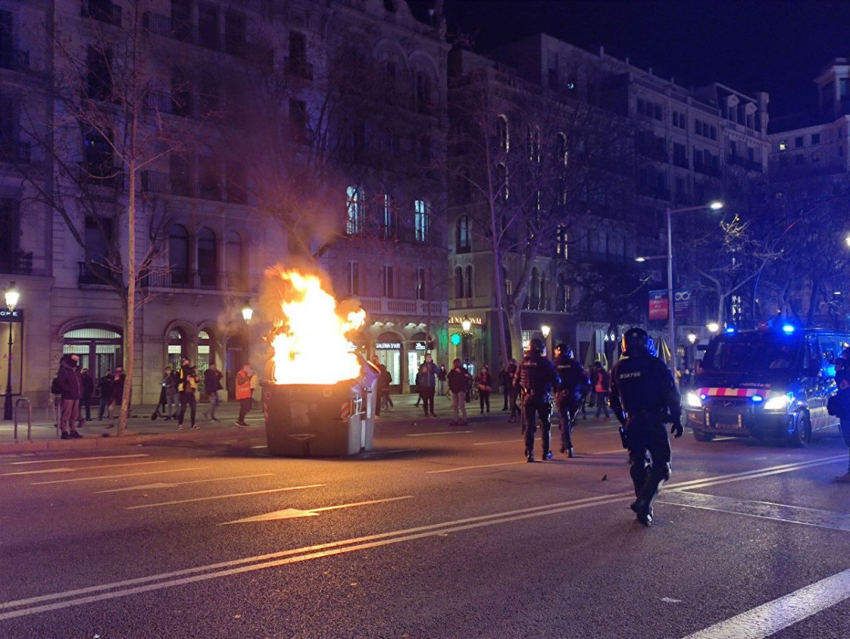 Cremen un contenidor en el passeig de Gràcia de Barcelona durant la manifestació en suport a Pablo Hasel