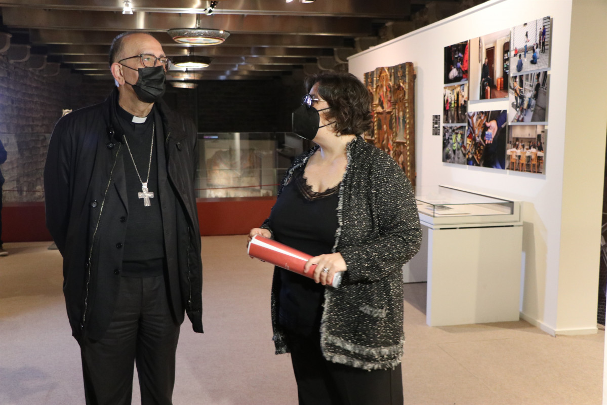El Arzobispo de Barcelona, Juan José Omella, con la co-comisaria de la exposición  “COVID-19: Obre els Ulls” de Càritas Diocesana de Barcelona, Marta Pluja, en el Museu Diocesà de Barcelona, e