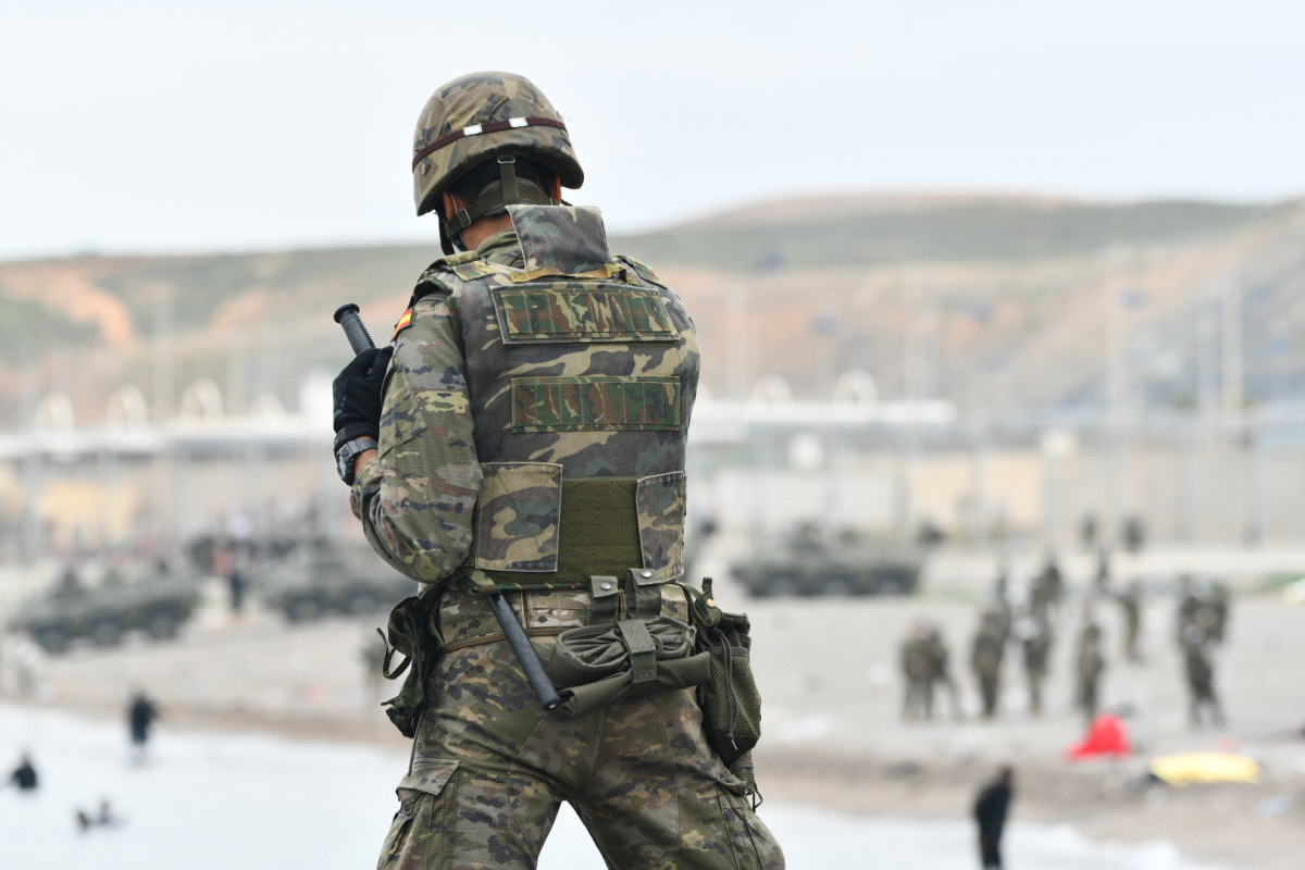 Un militar del ejército español vigila durante las devoluciones en caliente que están efectuando a los migrantes que han entrado en Ceuta procedente de Marruecos