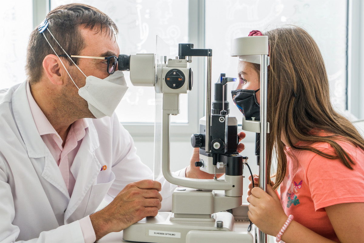 El oftalmólogo y cirujano del Hospital Sant Joan de Déu Jaume Català junto a la menor de 12 años que nació con una distrofia hereditaria de la retina que han tratado con la terapia génica 'Luxtu
