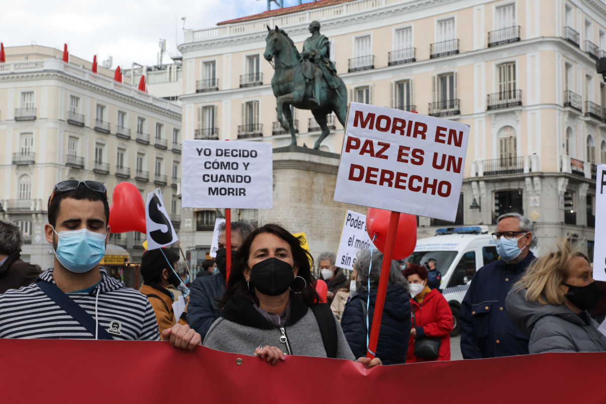 Archivo - Una mujer con un cartel en el que se lee: `Morir en paz es un derecho´ durante una concentración de Derecho a Morir Dignamente en la Puerta del Sol, en Madrid (España), a 18 de marzo de 2