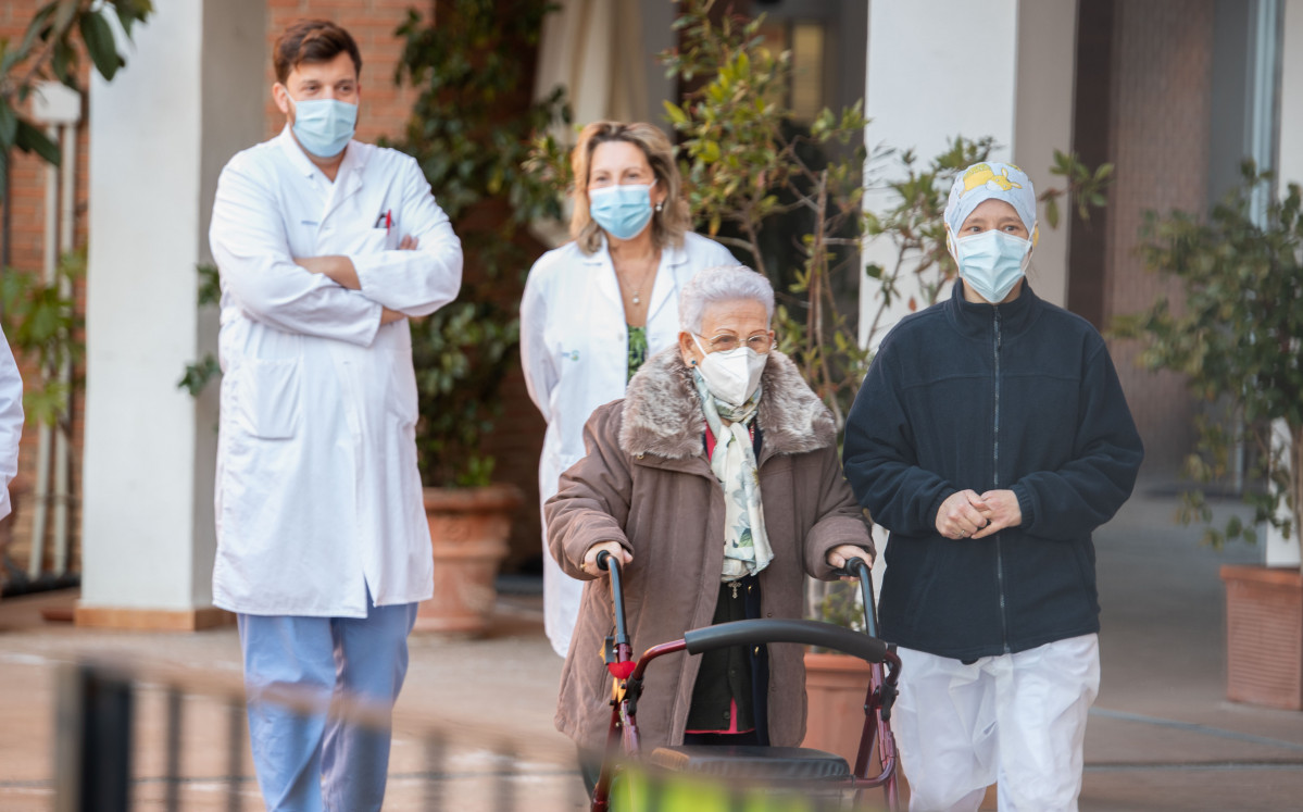 Araceli y Mónica, la residente más longeva de la Residencia de mayores Los Olmos y la sanitaria más joven, acompañadas de personal del geriátrico, tras recibir la segunda dosis de la vacuna Pfize
