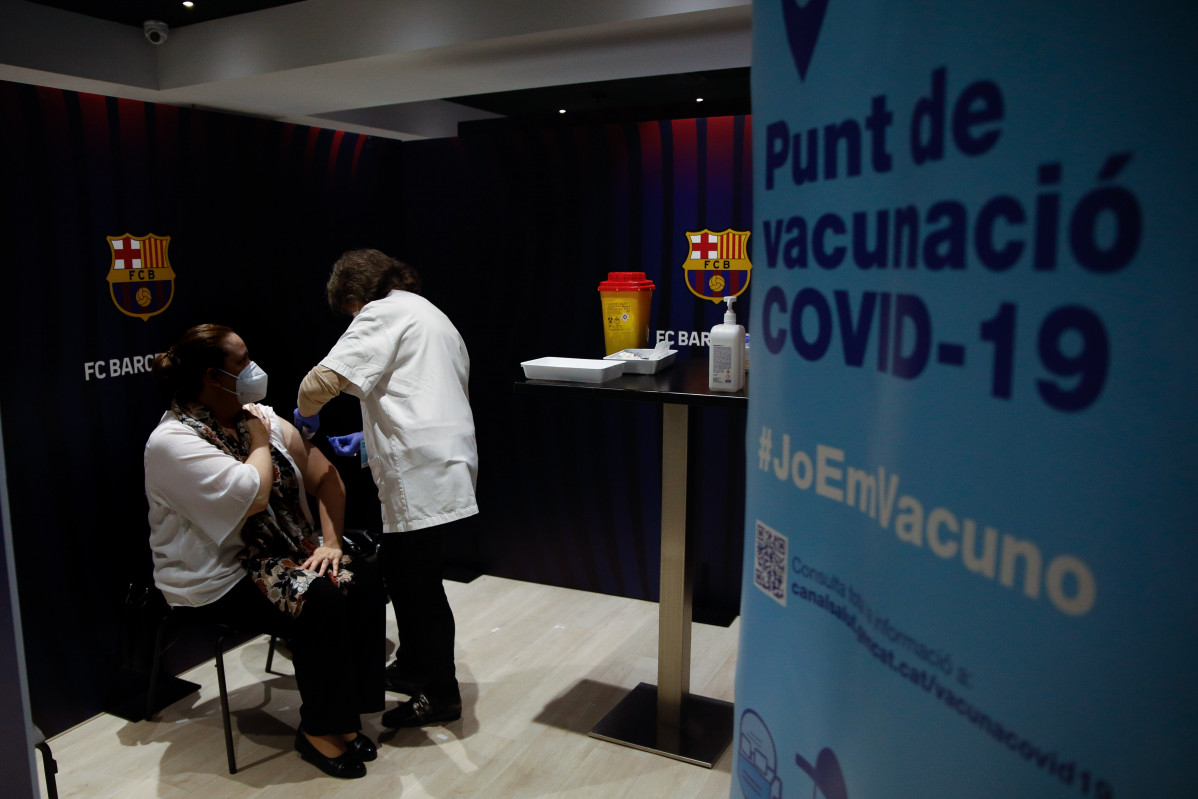 Archivo - Una mujer recibe la primera dosis de la vacuna de Pfizer contra el Covid-19 en el Camp Nou de Barcelona.