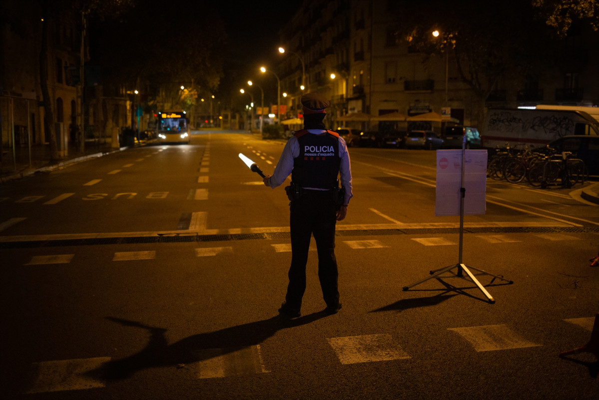 Archivo - Un mosso d'Esquadra colabora en un control durante el toque de queda impuesto por la crisis sanitaria del Covid-19 desde las 22.00 horas a las 6.00 del día siguiente, en Barcelona, Cataluny