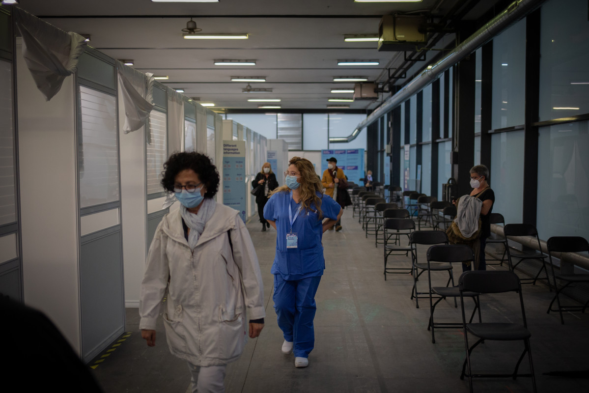 Archivo - Una mujer y una sanitaria en el circuito de vacunación de Fira de Barcelona, a 26 de abril de 2021, en Barcelona, Cataluña (España). El circuito de vacunación es una prueba piloto de vac