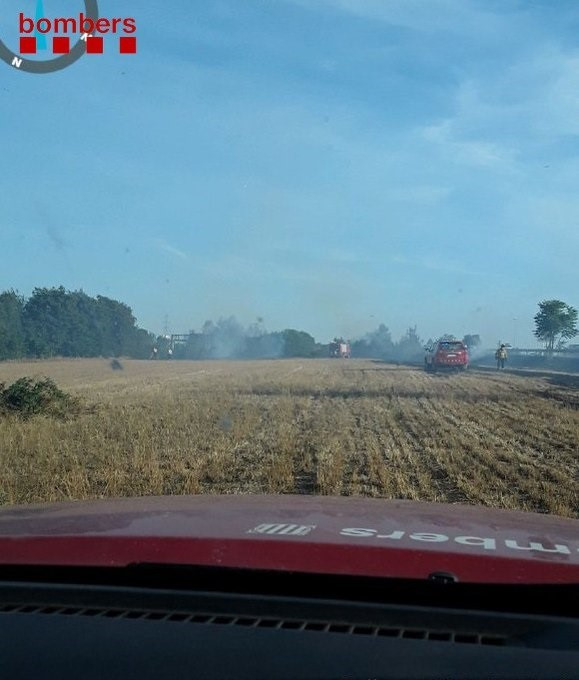 Los Bombers trabajan en un incendio en un campo segado en Girona