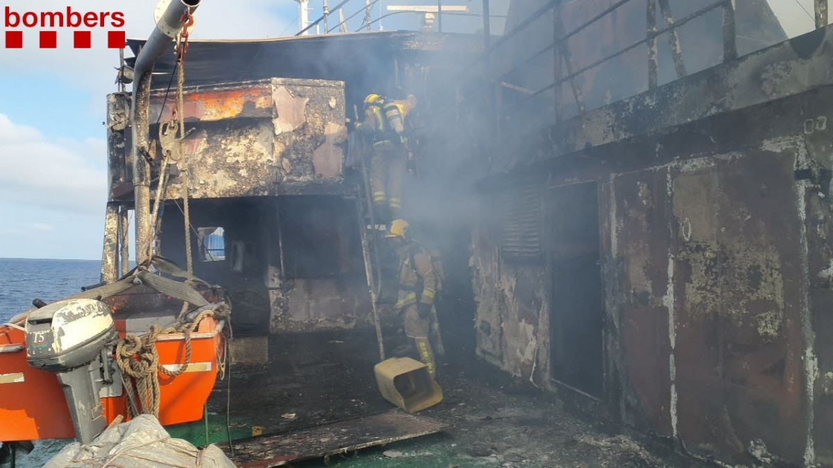 Los bomberos continúan trabajando en el incendio de un barco en el Port de Tarragona la tarde de este viernes.