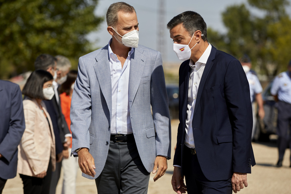El Rey Felipe VI (i) y el presidente del Gobierno, Pedro Sánchez, conversan a su llegada al Pabellón de Cuadros de Mando de la Base Aérea de Torrejón donde han acudido para visitar el dispositivo 