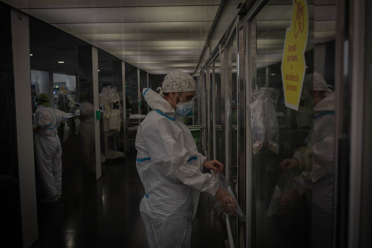 Archivo - Un trabajador sanitario protegido en una UCI (Archivo)