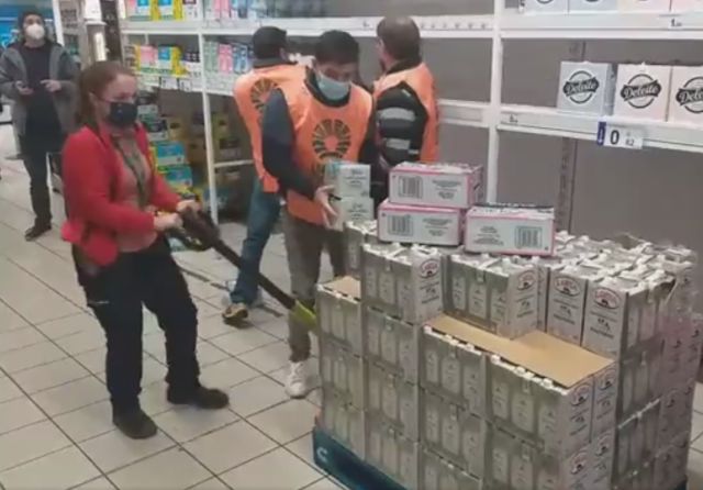 GanaderosretirandolecheLarsaenunstanddeunhipermercadodeSantiagoenunaimagendeUninsAgrarias