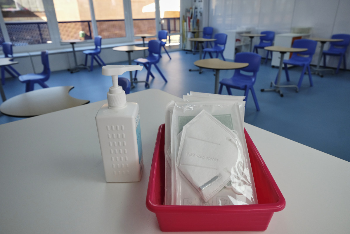 Archivo - Mascarillas y gel desinfectante en la mesa del profesor de un aula (archivo)