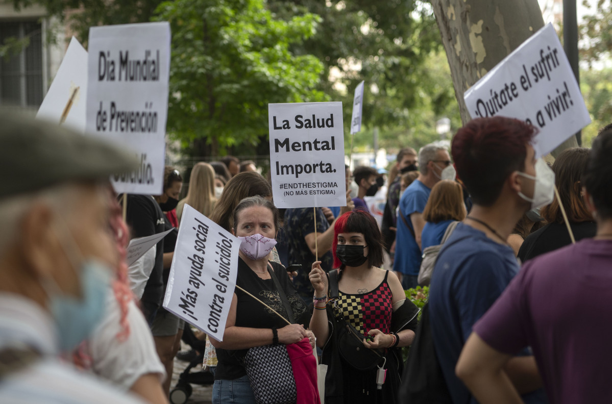Una mujer sostiene una pancarta donde se lee 