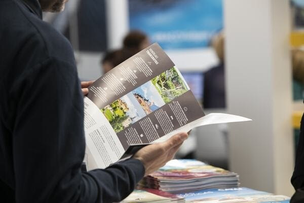 Archivo - Una persona lee un folleto en el B-Travel