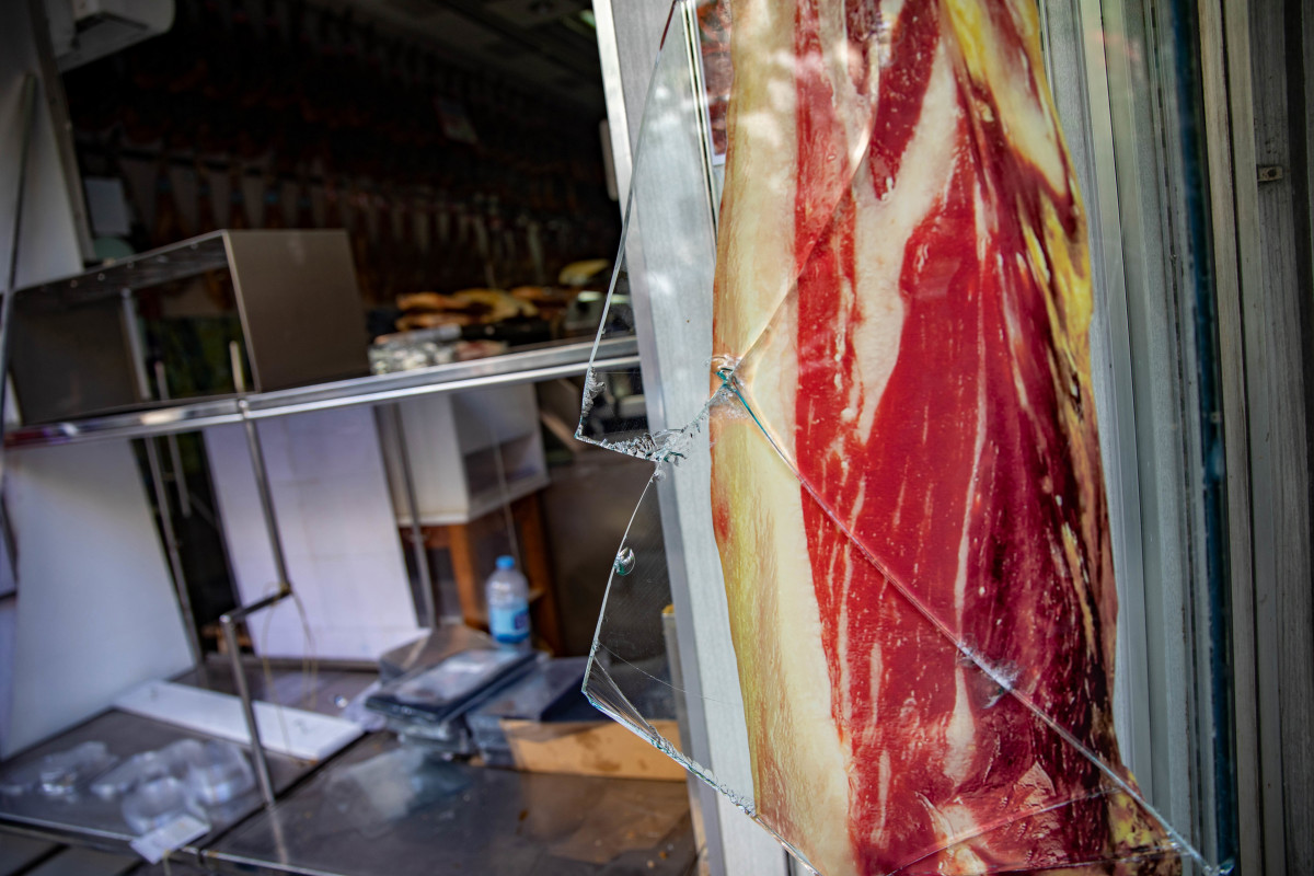 Desperfectos y cristales rotos el escaparate de una charcutería causados por los altercados en las Fiestas de la Mercè