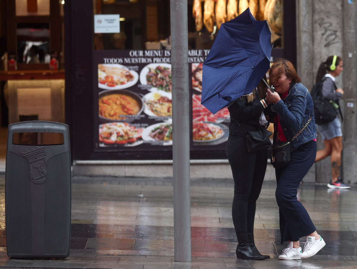 Dos chicas intentan controlar su paraguas, en la calle Gran Vía, a 20 de octubre, en Madrid (España).