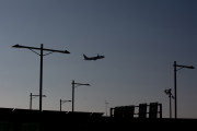 Archivo - Un avión sobrevuela el Aeropuerto de Barcelona-El Prat
