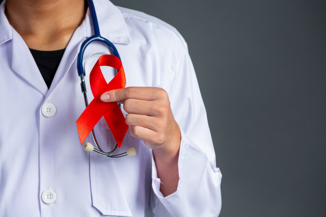 Thedoctorholdsredribbonhivawarenessawarenessworldaidsdayandworldsexualhealthday