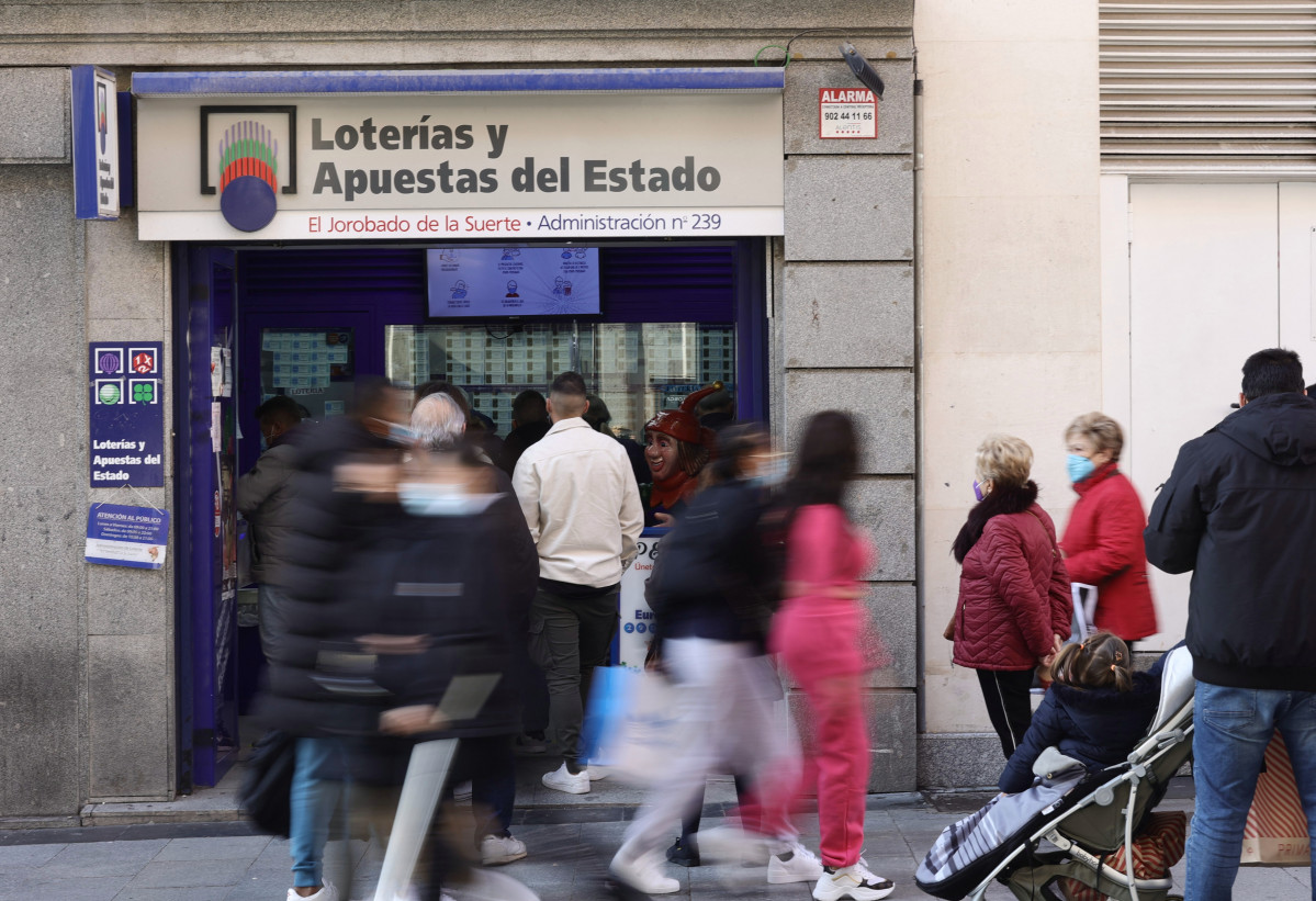 Varias personas en las inmediaciones de la administración de loterías 'El jorobado de la suerte', tres días antes del Sorteo de La Lotería del Niño, a 3 de enero de 2022, en Madrid, (España).