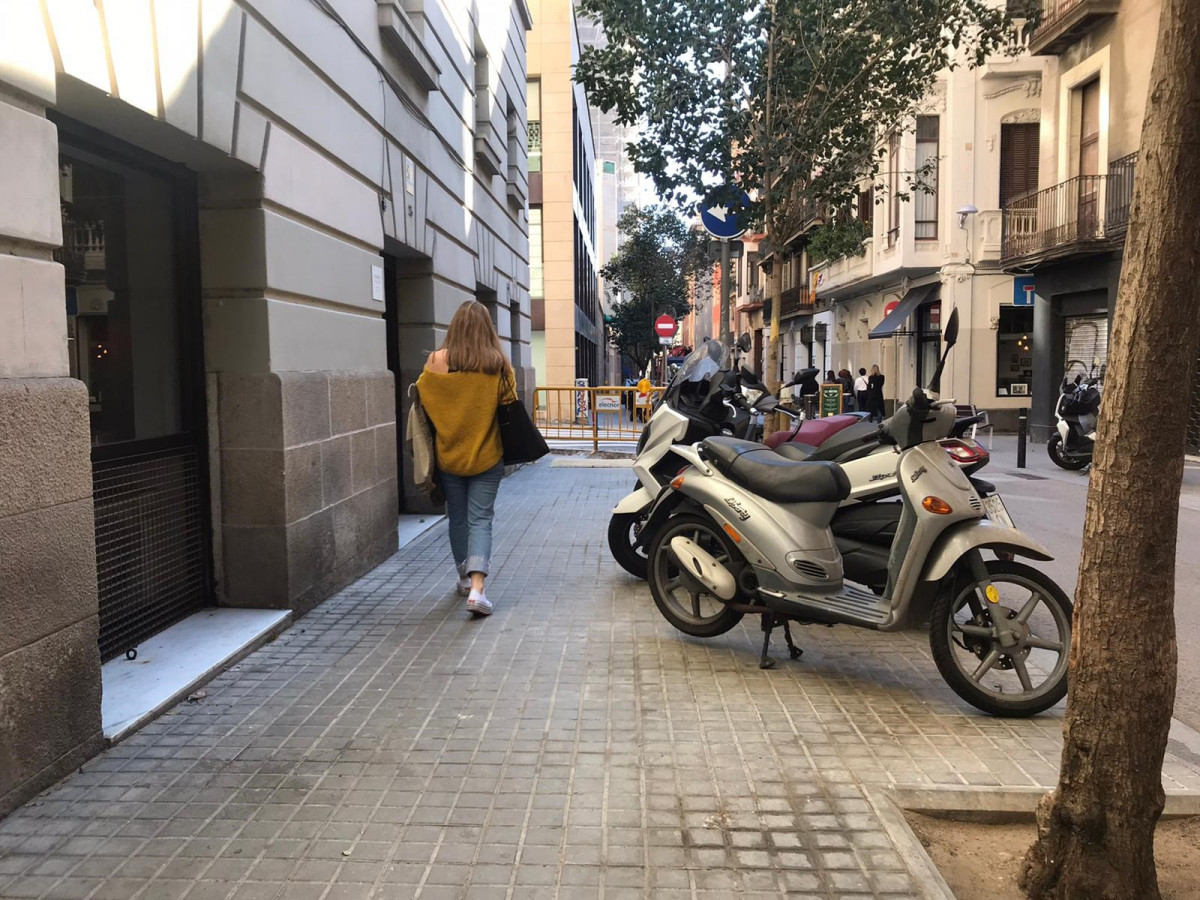 Archivo - Motos aparcadas en la acera en una calle del barrio de la Vila de Gràcia
