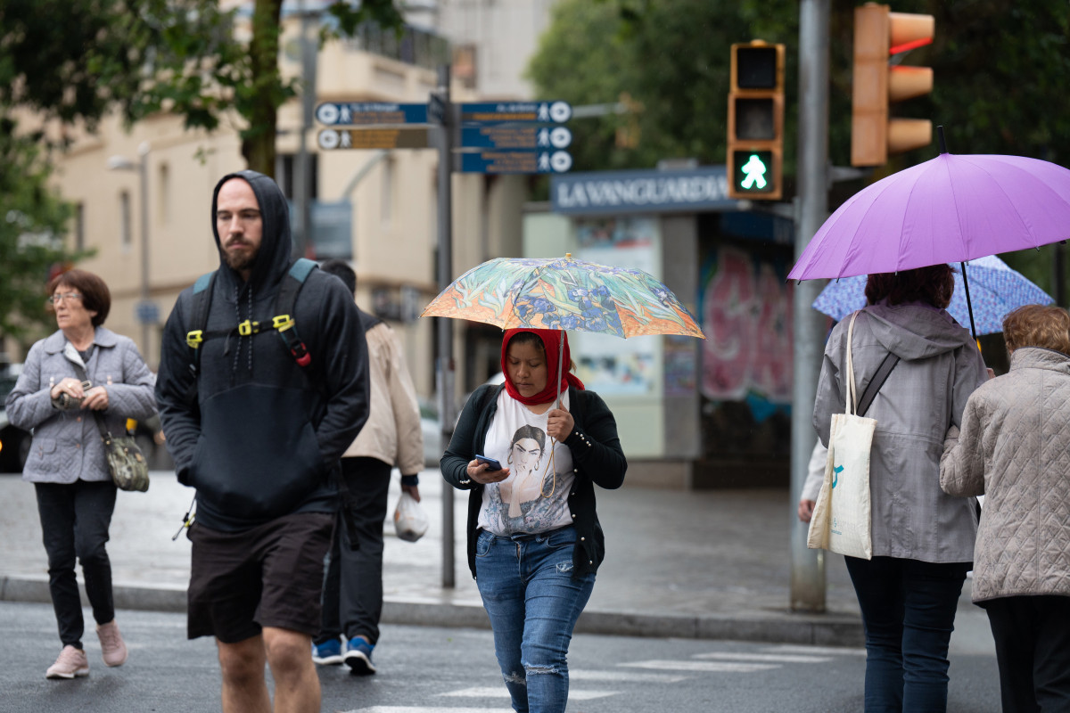 Varias personas con paraguas pasean por una de las calles de la ciudad, a 12 de mayo de 2023, en Barcelona, Catalunya (España).