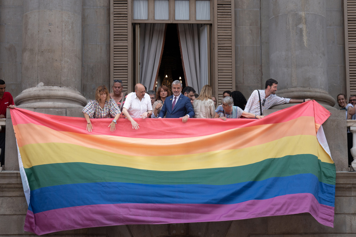 El alcalde de Barcelona, Jaume Collboni (4d), ayuda a colgar la bandera LGTBIQ+  durante el Día Internacional del Orgullo en el Ayuntamiento de Barcelona, a 28 de junio de 2023, en Barcelona, Catalun
