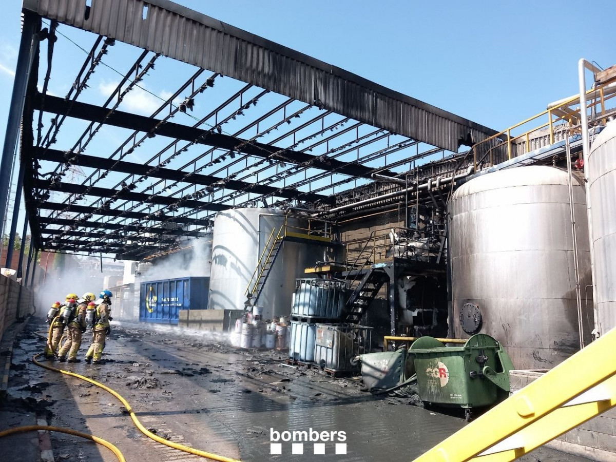 Bombers de la Generalitat en la nave incendiada en Sant Boi de Llobregat (Barcelona).