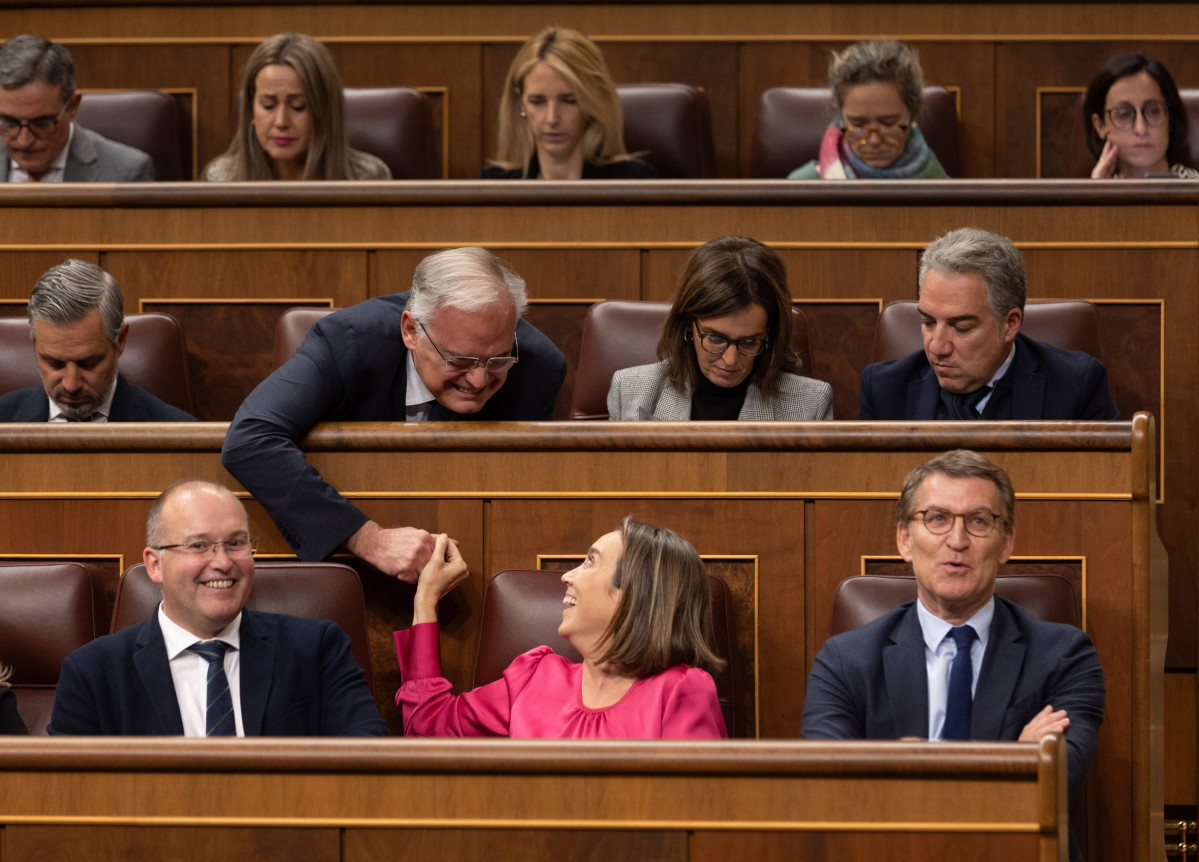 La secretaria general del PP, Cuca Gamarra (2d), y el diputado del PP Esteban González Pons (2i) se dan la mano durante una sesión plenaria, en el Congreso de los Diputados.