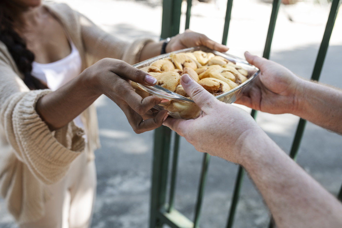 Mujer ofreciendo comida al vecino