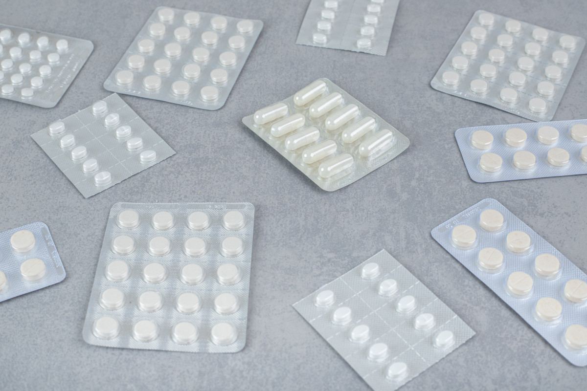 Muchas ampollas pastillas blancas sobre superficie gris