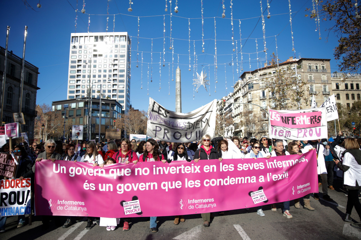 Decenas de personas con pancartas durante una manifestación de ‘Infermeres de Catalunya’ en su huelga indefinida, a 13 de enero de 2024, en Barcelona, Catalunya (España). El sindicato ‘Inferme