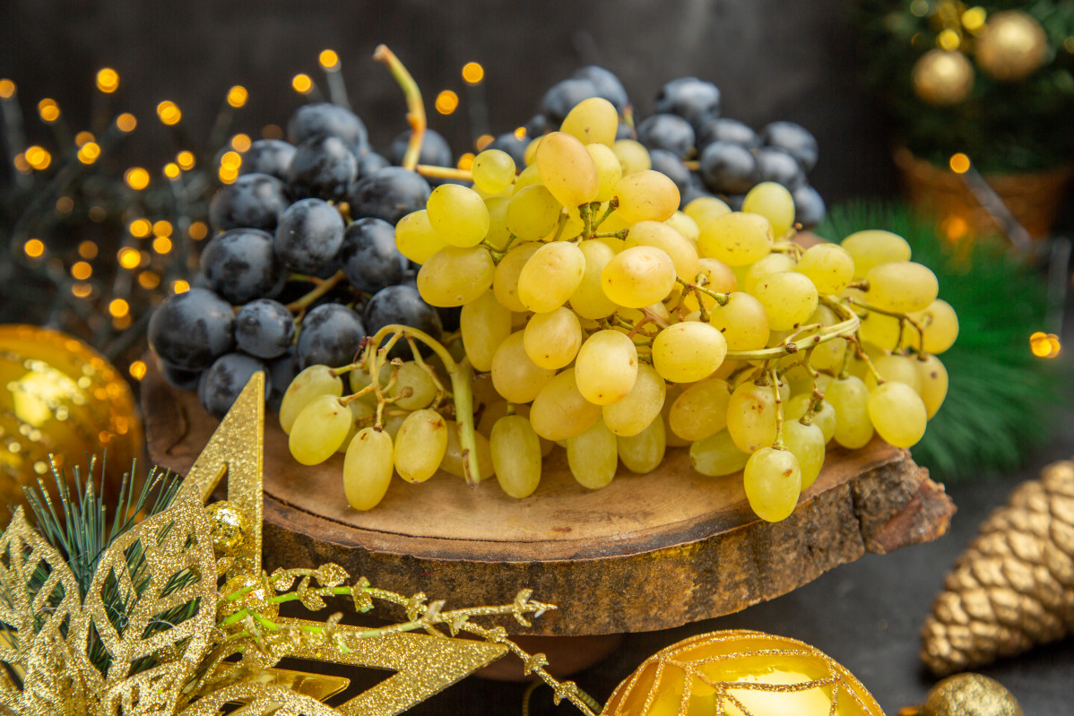 Front view fresh grapes around christmas toys dark background fruit wine color xmas