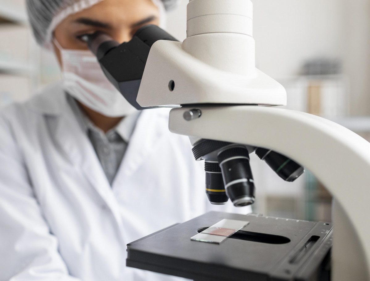 Cerrar cientifico mirando portaobjetos de vidrio